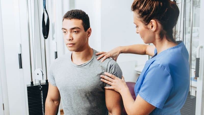 physical therapist working on shoulder of a patient