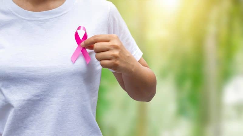woman holding pink breast cancer awareness ribbon