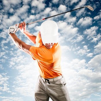 male golfer in orange shirt and white hat swinging club